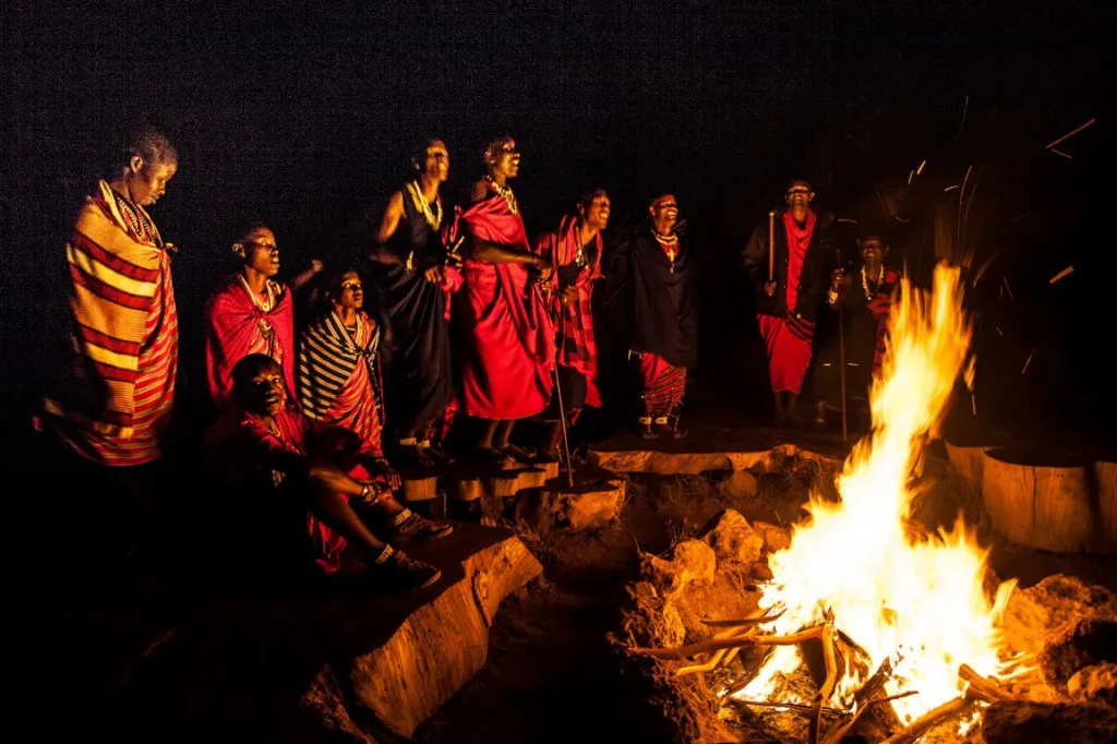 Group of Maasai men performing adumu jumping dance on open plains